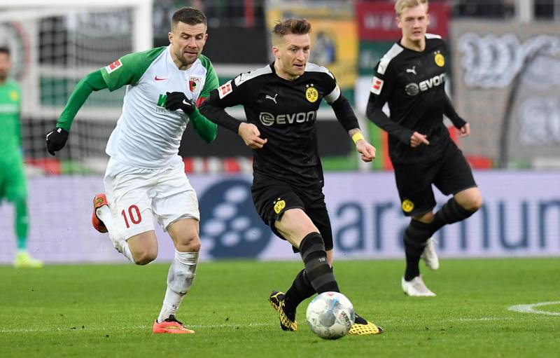 Augsburg midfielder Daniel Baier and Dortmund forward Marco Reus vie for the ball. AFP