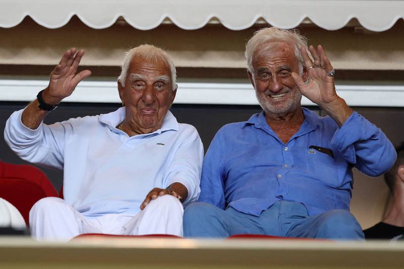 In this file photo taken on August 4, 2017, Jean-Paul Belmondo, right, and Charles Gerard wave as they attend the French football match Monaco vs Toulouse, at the Louis II Stadium in Monaco. AFP