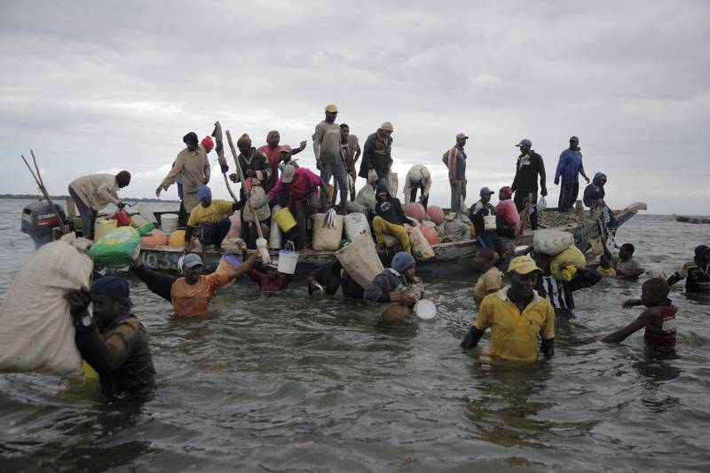 Fishermen swim out from an incoming boat, some with their overnight catch. Artisanal fisheries on Kenya's coast say climate change and overfishing by large foreign vessels is draining the Indian Ocean of its yellowfin tuna stocks. AP Photo