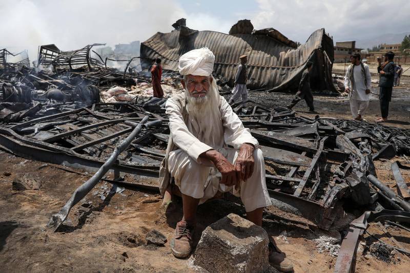 An Afghan driver poses for a photograph, a day after dozens of logistic trucks, mostly petrol tankers, have burned in flames in the outskirt of Kabul. EPA