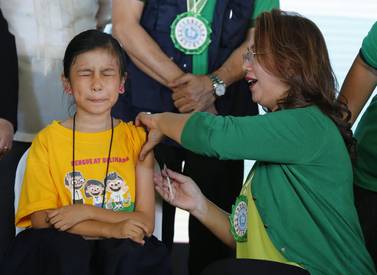 Filipino health secretary Janette Garin administers an anti-dengue jab to a schoolgirl in Marikina city yesterday. Francis Malasig / EPA