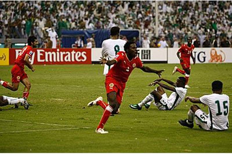 Ismail Abdullatif, centre, celebrates helping his country progress to the play-offs as the Saudi players around him drop to the floor in dejection.