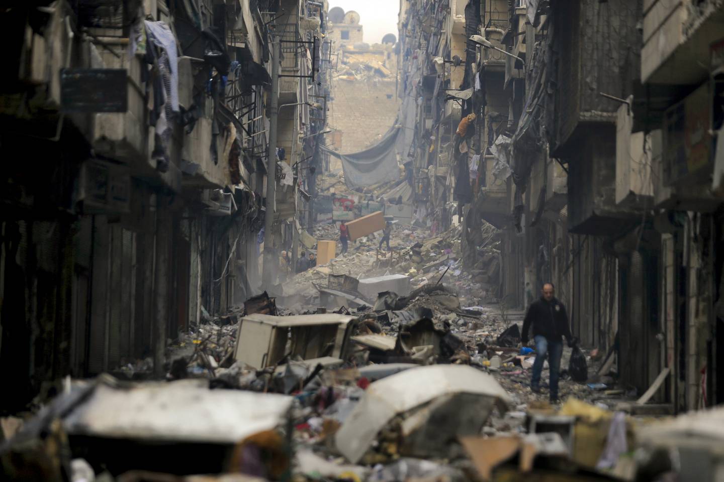 Residents walk through the destruction of the once rebel-held Salaheddine district in eastern Aleppo, Syria, in 2017. AP