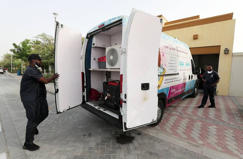 Assistant pet groomer Okwudiri John Ani, left and pet groomer 
Femi Moses Olajide, right, from Miss Meow mobile pet grooming arrive for a session at Jumeirah Park in Dubai.
