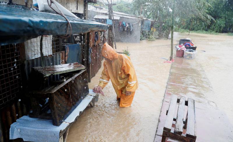 A man stands in floodwaters outside his house in Marikina, Metro Manila. Reuters