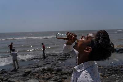 A boy drinks soda beside the Arabian Sea in Mumbai. AP