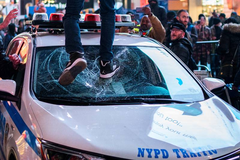 A protester breaks the windscreen of a police car during a demonstration in New York. Reuters