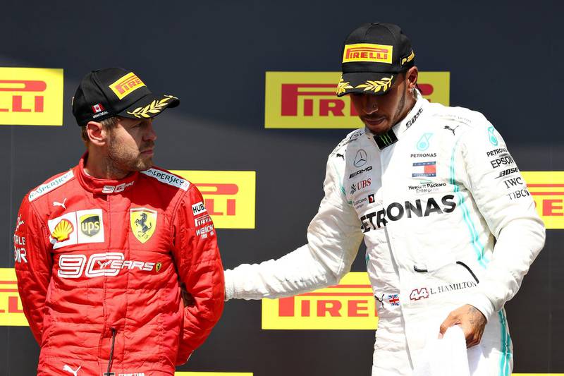 MONTREAL, QUEBEC - JUNE 09: Race winner Lewis Hamilton of Great Britain and Mercedes GP pulls second placed Sebastian Vettel of Germany and Ferrari onto the top step of the podium during the F1 Grand Prix of Canada at Circuit Gilles Villeneuve on June 09, 2019 in Montreal, Canada.   Mark Thompson/Getty Images/AFP