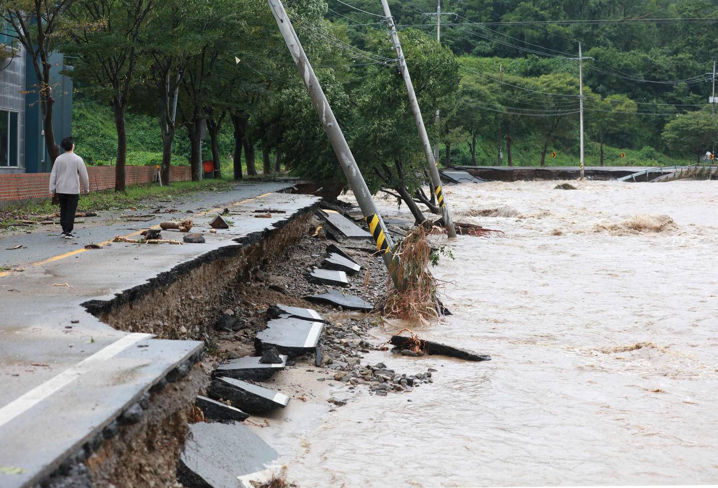 A man walks along a damaged road in Gyeongju on Tuesday as Typhoon Hinnamnor hit South Korea's southern provinces. AFP