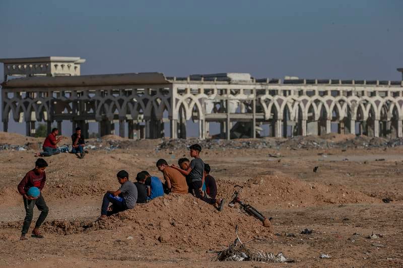 Youths play near a destroyed building on the grounds of the airport.  