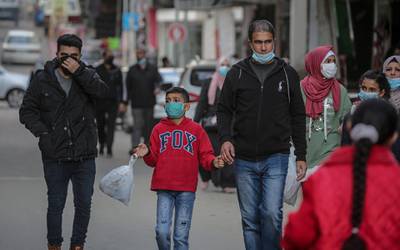 Palestinians wearing protective face masks walk in the market amid the ongoing coronavirus COVID-19 pandemic in Gaza City. The Ministry of Interior in Gaza City announced new measures in light of the increasing number of new infections with the Coronavirus, which are the closure of schools, universities, mosques and government ministries until further notice, as well as work from six in the morning until six in the evening only, and on Friday and Saturday of every week, a comprehensive closure.  EPA