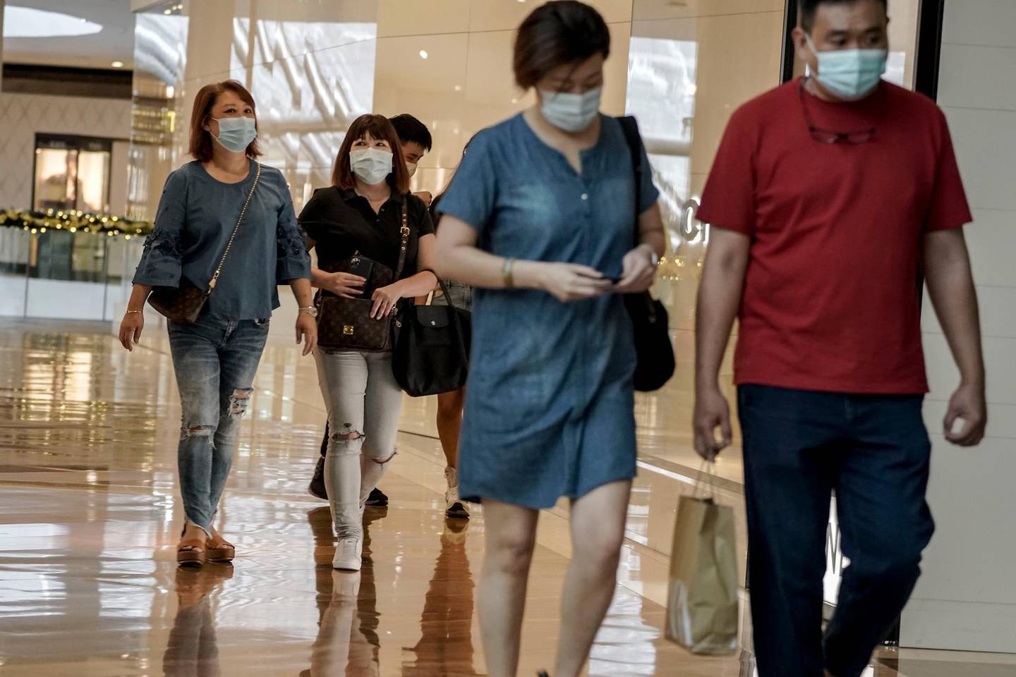epa08824819 Visitors walk through the Marina Bay Sands shopping mall in Singapore,  17 November 2020. Singapore's economy is predicted to take 'much longer' to recover from the economic fallout caused by the global Covid-19 coronavirus pandemic than previous recessions. Singapore's Prime Minister Lee Hsien Loong says that the government's budget will likely run as a deficit through to early 2021.  EPA/WALLACE WOON