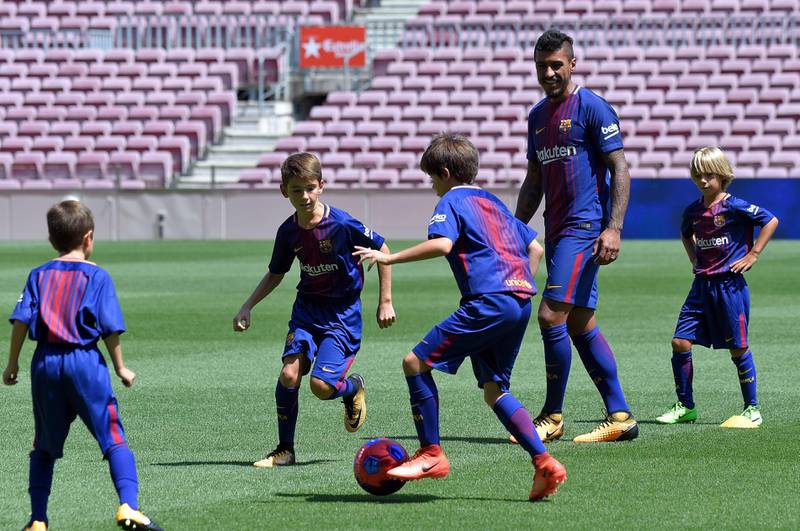 Barcelona's new Brazilian midfielder Paulinho football with young fans. Lluis Gene / AFP
