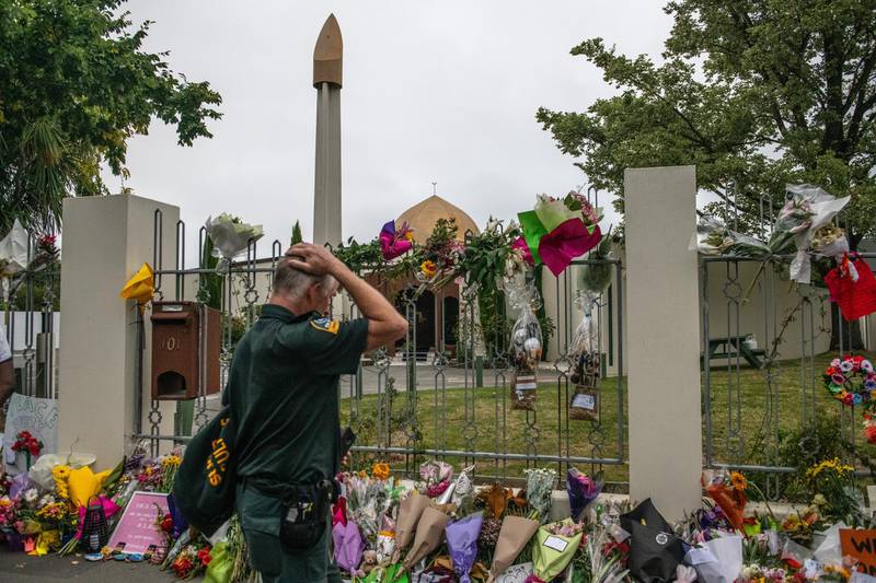 A member of the emergency services holds his head as he views flowers and tributes outside Al Noor mosque after it was officially reopened following last week's attack, on March 23, 2019. Getty Images
