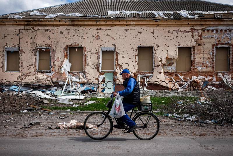 A cyclist passes a destroyed building in Derhachi village, near besieged city Kharkiv, in north-eastern Ukraine. AFP