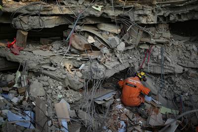 A Turkish rescue worker checks a collapsed building in Adiyaman. AP