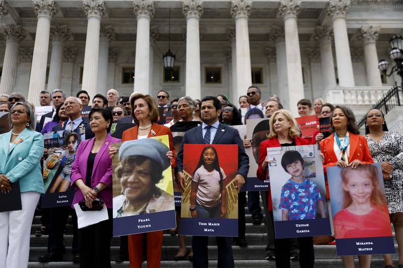 US House Speaker Nancy Pelosi stands with fellow Democrats holding photographs of the victims of the mass shootings in Buffalo, New York, and Uvalde, Texas. Getty Images / AFP
