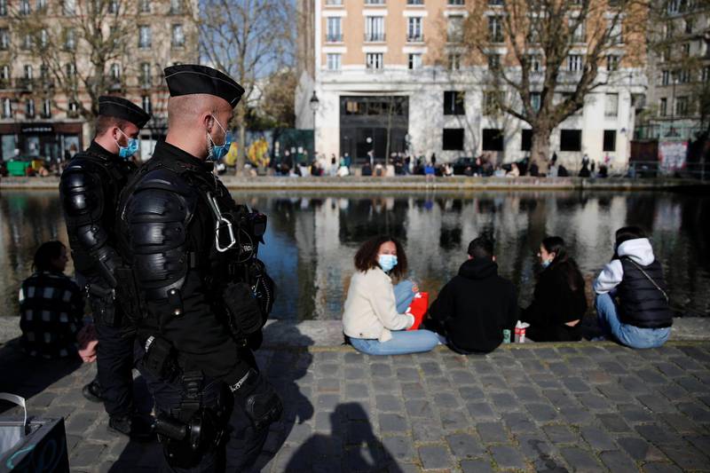 Police officers monitor people enjoying the Paris weather. Reuters