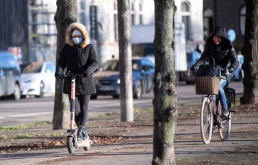 A woman rides an electric scooter wearing a protective mask, amid the continuous spread of the coronavirus disease (COVID-19) pandemic, along Standvagen in Stockholm, Sweden, November 20, 2020. TT News Agency/Fredrik Sandberg via REUTERS ATTENTION EDITORS - THIS IMAGE WAS PROVIDED BY A THIRD PARTY. SWEDEN OUT. NO COMMERCIAL OR EDITORIAL SALES IN SWEDEN.