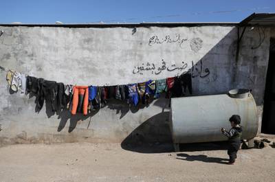 Clothes are hanged on a rope to dry near the wall in Atmah IDP camp. Reuters