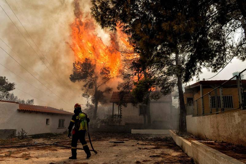 A firefighter tries to extinguish hotspots during a wildfire in Kineta, near Athens. AFP