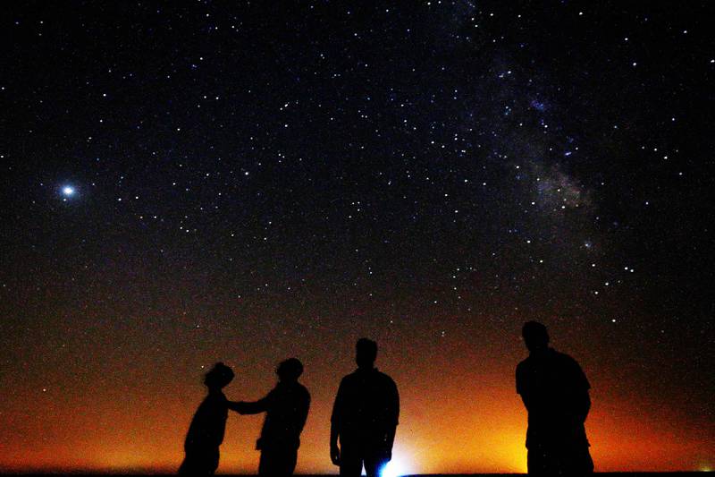 People look at the Milky Way galaxy rising in the night sky in Kuwait's Al Salmi desert, 120Km north of the capital.