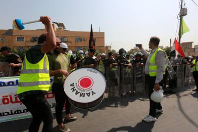 epa08656684 Jobless graduates chant slogans and beat a drum as riot police forces take up position during a demonstration near the heavily fortified Green Zone which houses the Iraqi government offices in central Baghdad, Iraq, 09 September 2020. Thousands of university graduates and jobless people continue their protests in Baghdad outside government ministries demanding jobs, while the Iraqi government admits it has not planned for the large numbers of students coming into the job market every year.  EPA-EFE/AHMED JALIL *** Local Caption *** 56329555