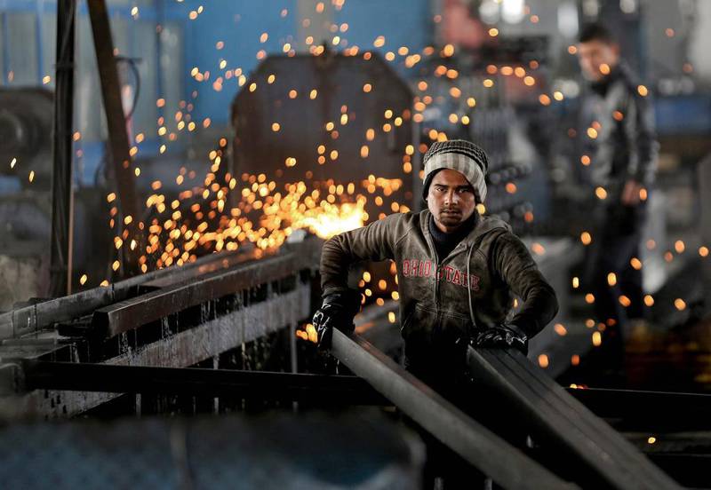 An India worker arranges steel tubes at a factory in the Muwaqer Industrial Estate, northern Jordan. A new trade deal with Europe, a rush of foreign investment and ambitious public works are to put 200,000 Syrian refugees to work in the country. Raad Adayleh/AP Photo