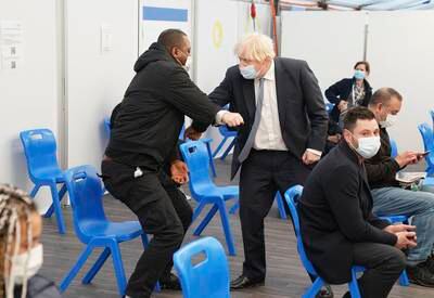 Britain's Prime Minister Boris Johnson speaks to members of the public before receiving his booster jab at St Thomas' Hospital in London. AP
