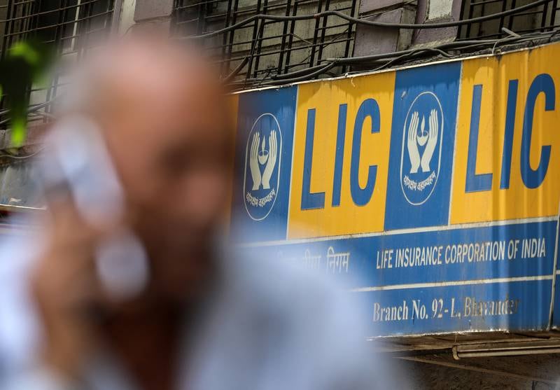 A man talks on the phone near a Life Insurance Corporation (LIC) branch office in the outskirts of Mumbai. India's largest-ever initial public offering of LIC, which is expected to have raised $2.74bn, is part of plans by Prime Minister Narendra Modi to privatise some industries and fill state coffers. EPA
