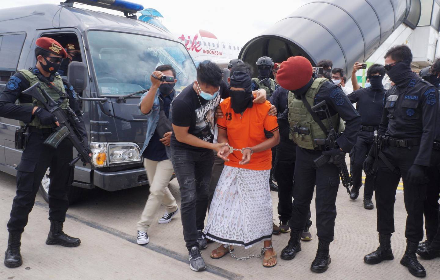 Police escort 57-year-old Zulkarnaen, a senior leader of the Al-Qaeda-linked Jemaah Islamiyah (JI), who had been on the run for his alleged role in the 2002 Bali bombings, upon arrival at Jakarta’s Soekarno-Hatta International Airport in Tangerang on December 16, 2020. (Photo by FAJRIN RAHARJO / AFP)
