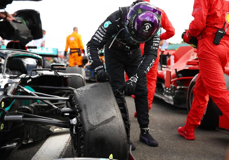 Formula One F1 - British Grand Prix - Silverstone Circuit, Silverstone, Britain - August 2, 2020 Mercedes' Lewis Hamilton looks at his tyre after winning the race with a puncture on the final lap Pool via REUTERS/Bryn Lennon