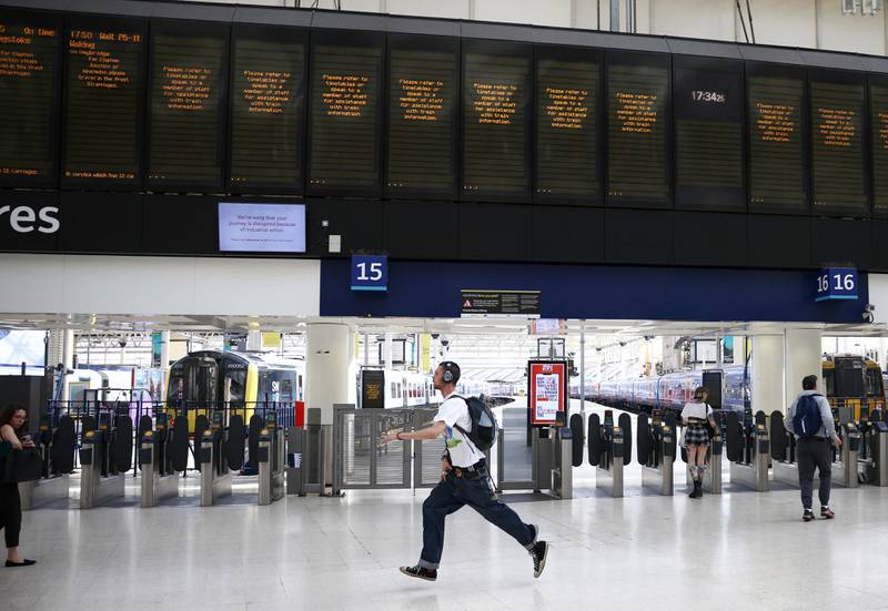A passenger runs to catch a train at Waterloo station in London before train services end early on Tuesday evening. Reuters