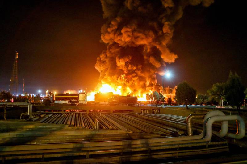 A picture taken late on June 2, 2021, shows fire raging at an oil refinery in the Iranian capital Tehran. A fierce blaze broke out at the refinery in southern Tehran after a liquefied gas line leaked and exploded, the head of the capital's crisis team said on state television. / AFP / TASNIM NEWS / Vahid AHMADI
