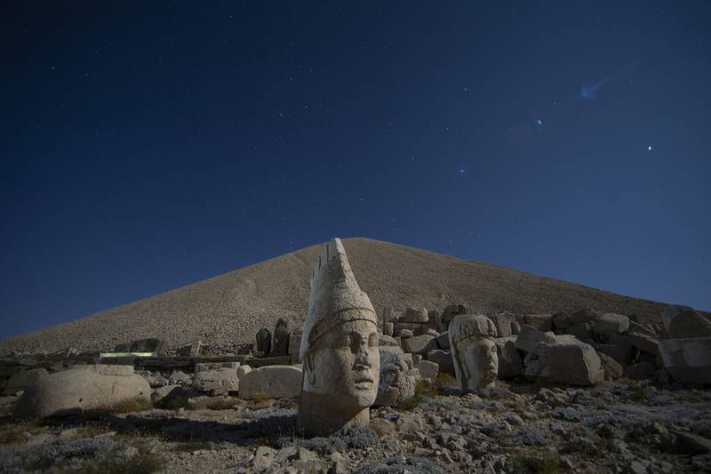 Ancient statues are seen as stargazers gather to watch the Perseid meteor shower atop Mount Nemrut in southeastern Turkey, Saturday, Aug.  13, 2022.  Hundreds spent the night at the UNESCO World Heritage Site for the annual meteor show that stretches along the orbit of the comet Swift–Tuttle.  Perched at an altitude of 2,150 meters (over 7,000 feet), the statues are part of a temple and tomb complex that King Antiochus I, of the ancient Commagene kingdom, built as a monument to himself.  (AP Photo / Emrah Gurel)