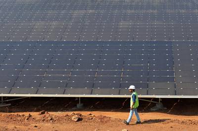An Indian worker conducts routine checks of solar panels at "Shakti Sthala", the 2000 Megawatt solar power park in Pavagada Taluk, situated about 150 kms from Bangalore on March 1, 2018. - The 1st phase of Shakti Sthala, which was inaugurated today is coming up in an area of 13,000 acres with an investment of 165,000 million rupees by the time of its completion is said to be the world's largest solar park. (Photo by MANJUNATH KIRAN / AFP)