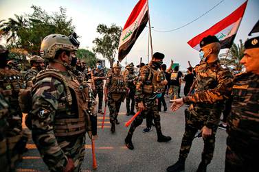 Iraqi security forces prevent protesters from breaking into the provincial council building during a protest demanding free elections in Basra, Iraq, on Tuesday, September 15, 2020. AP