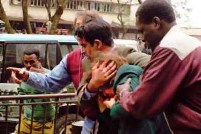 U.S. Ambassador Prudence Bushnell, center, is helped by unidentified men, as she is evacuated from the area of the U.S. Embassy following an explosion in downtown Nairobi, Friday, Aug. 7, 1998. Terrorist bombs exploded minutes apart outside the U.S. embassies in both Kenya and Tanzania Friday, killing more than 67 people, injuring 1,100 and turning buildings into mountains of shattered concrete. At least eight Americans were among the dead in Kenya and seven more were missing, U.S. Embassy spokesman Chris Scharf said. Bushnell, was cut on the lip and helped from Cooperative Bank House, near the embassy, where she had just given a news conference, embassy spokesman Bill Barr said. (AP Photo/Sayyid Azim)