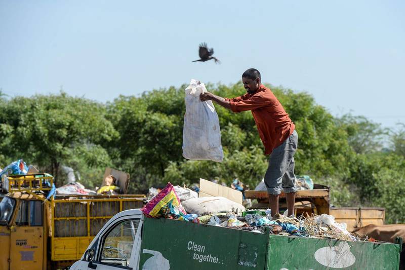 A man unloads waste materials at a garbage dump site on the outskirts of Hyderabad on the United Nations' World Environment Day.  AFP