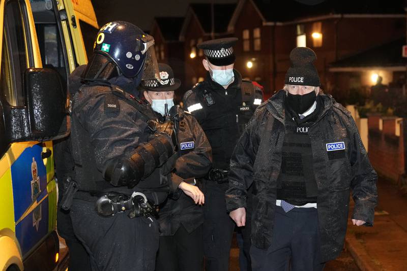 Mr Johnson observes an early morning police raid on a home in Liverpool as part of an operation to thwart drug dealing, in December, 2021. Getty 
