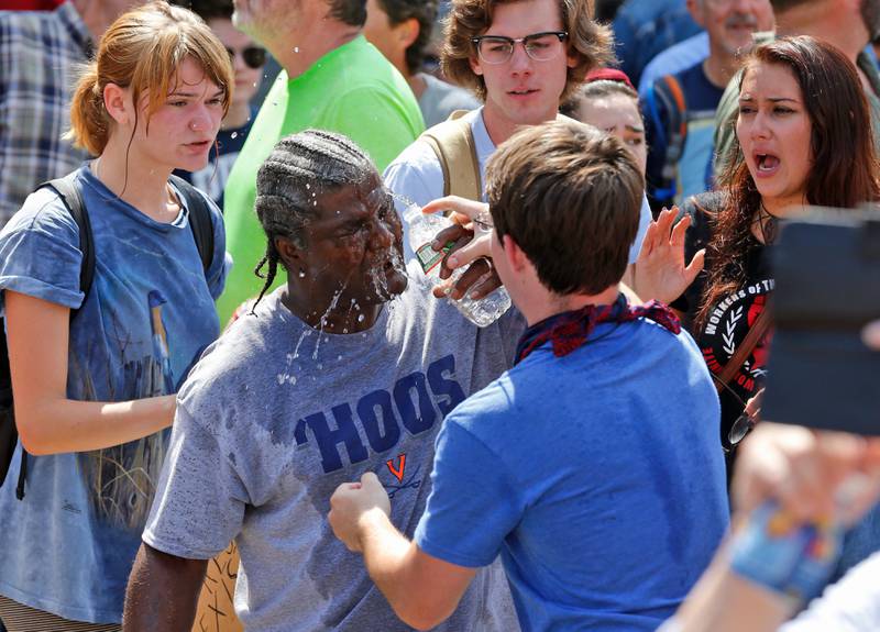 A counter demonstrator is splashed with water after he was hit by pepper spray by a white nationalist demonstrator at the entrance to Lee Park in Charlottesville. Steve Helber / AP