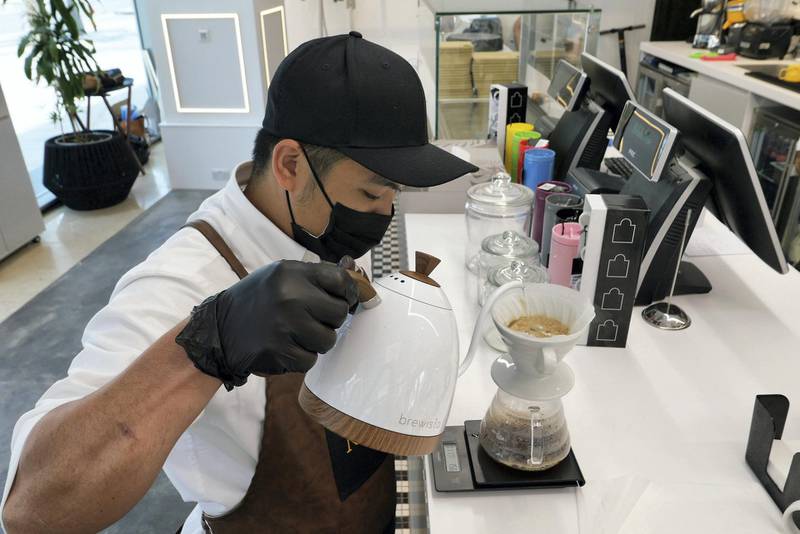 Staff preparing the B 60 coffee at The Name concept store and a resto café at Dubai Design District in Dubai on June 23,2021. Pawan Singh / The National. Story by Janice Rodrigues 