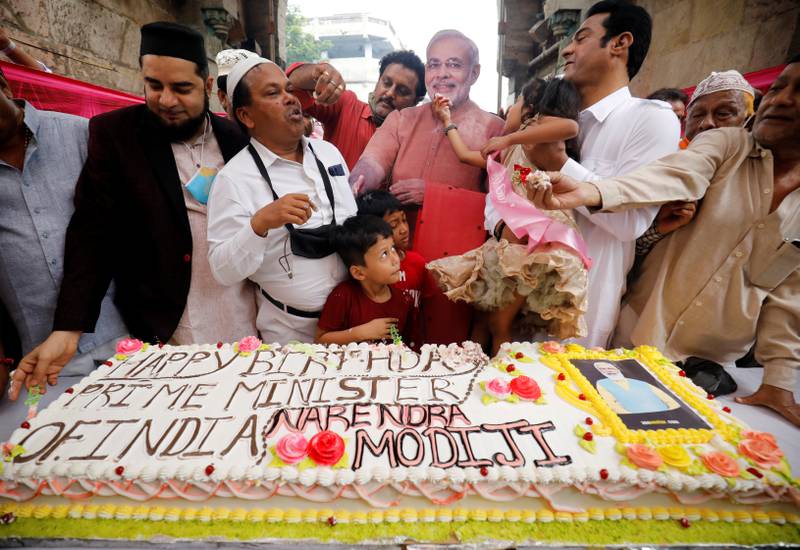 People cut a 71-kilogram cake to celebrate in Ahmedabad. Reuters