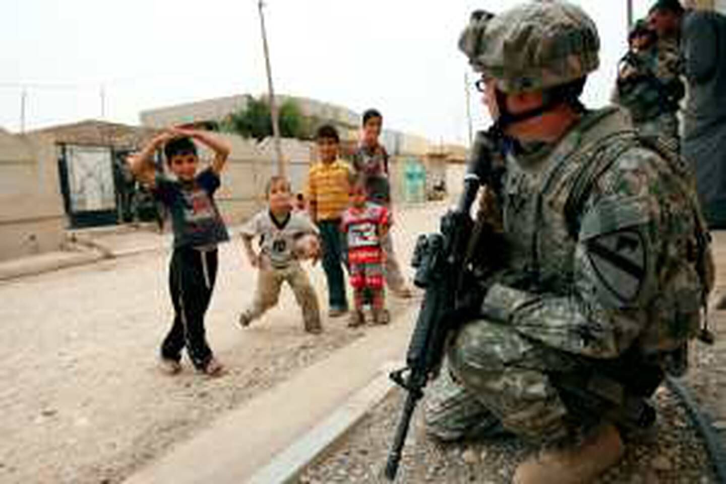 Iraqi children watch a US Army soldier from the 3rd Battalion 8th Cavalry Division on patrol in the Al-Naherwa district of the northern Iraqi city of Mosul on June 17, 2009, one day after a US soldier was killed and six people were wounded in violence across Iraq and two weeks before the scheduled American pullout from the country's urban centres.  AFP PHOTO / ALI AL-SAADI *** Local Caption ***  205570-01-08.jpg *** Local Caption ***  205570-01-08.jpg