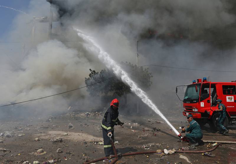 Firefighters extinguish a fire caused by the powerful blast, which killed at least one person. Reuters