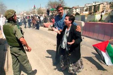 Palestinian legislator Hanan Ashrawi (right) argues with an Israeli soldier at the Ar-Ram checkpoint near the West Bank town of Ramallah, during a 2001 protest by Palestinian women against the Israeli closure of the Palestinian territories.