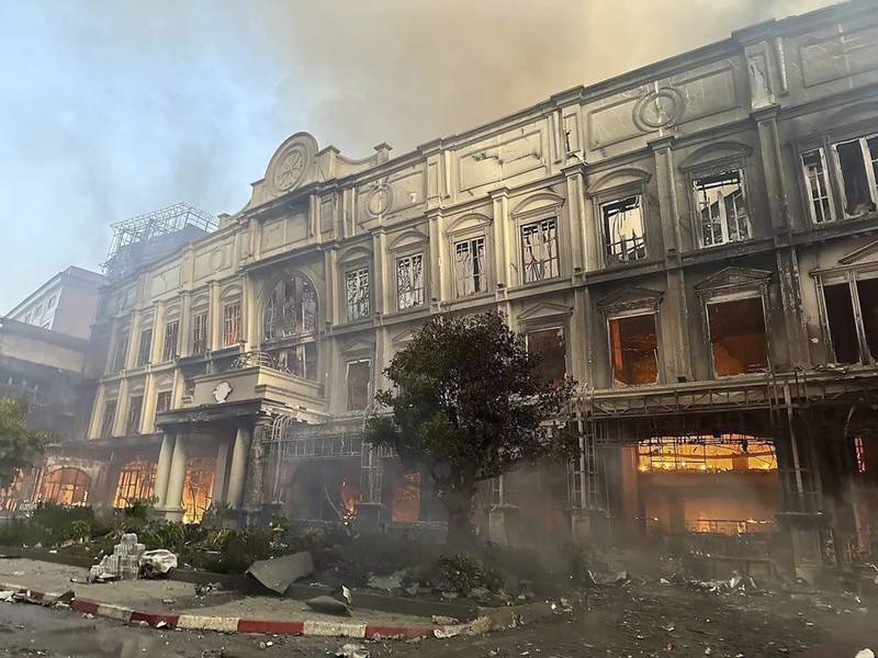 In this photo provided by Cambodia's Fresh News, a building burns near a Cambodia-Thai international border gate in Poipet, west of Phnom Penh, Cambodia, Wednesday, Dec.  28, 2022.  A fire burning through the Grand Diamond City Casino and Hotel has killed multiple people and injured dozens of others, police said Thursday, and neighboring Thailand sent firetrucks to help fight the blaze in a bustling border region.  (Fresh News via AP)