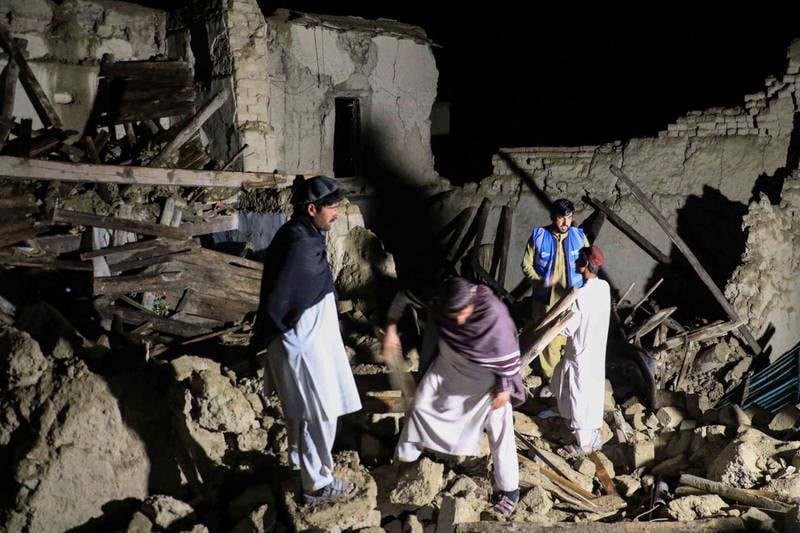 Rescue workers and local residents survey a damaged house after an earthquake hit the village of Gayan in Paktia province, Afghanistan. EPA
