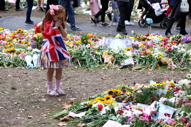 Ann Doran, 6, looks at floral tributes left in Green Park. Reuters