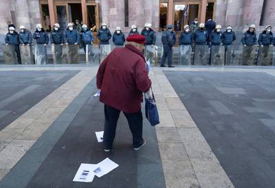 A demonstrator stands in front of Armenian police officers, who guard the house of parliament following protests, which erupted after the signing of a deal to end the military conflict over the Nagorno-Karabakh region, in Yerevan, Armenia. Reuters